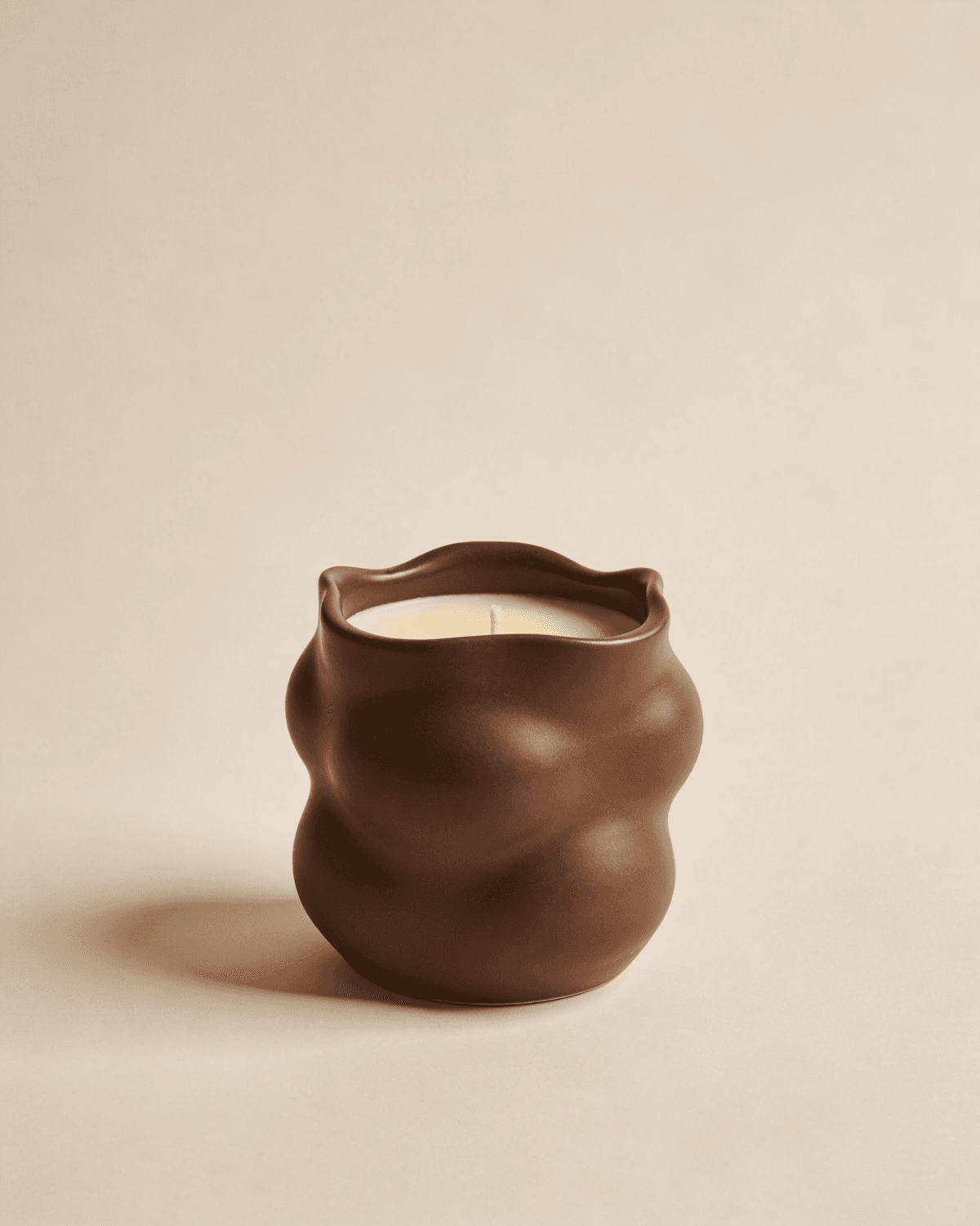 Cream candle in a brown wave ceramic holder